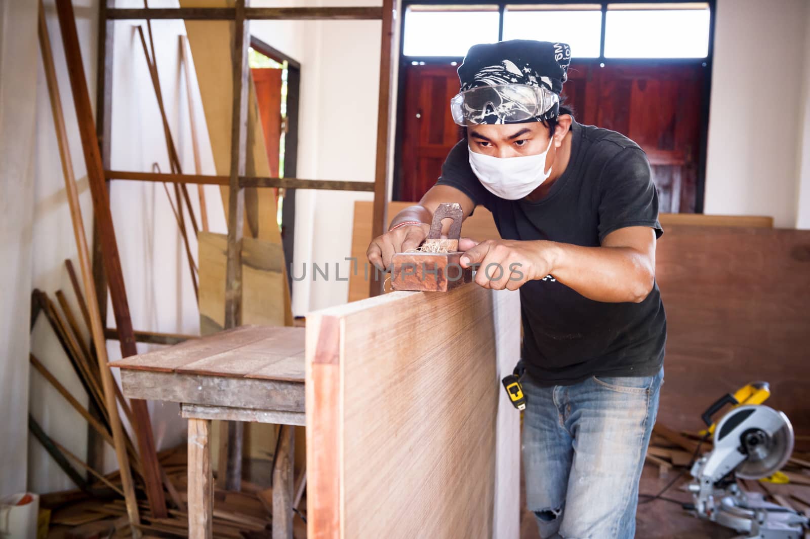 carpenter man take a planer tool with wood in workshop