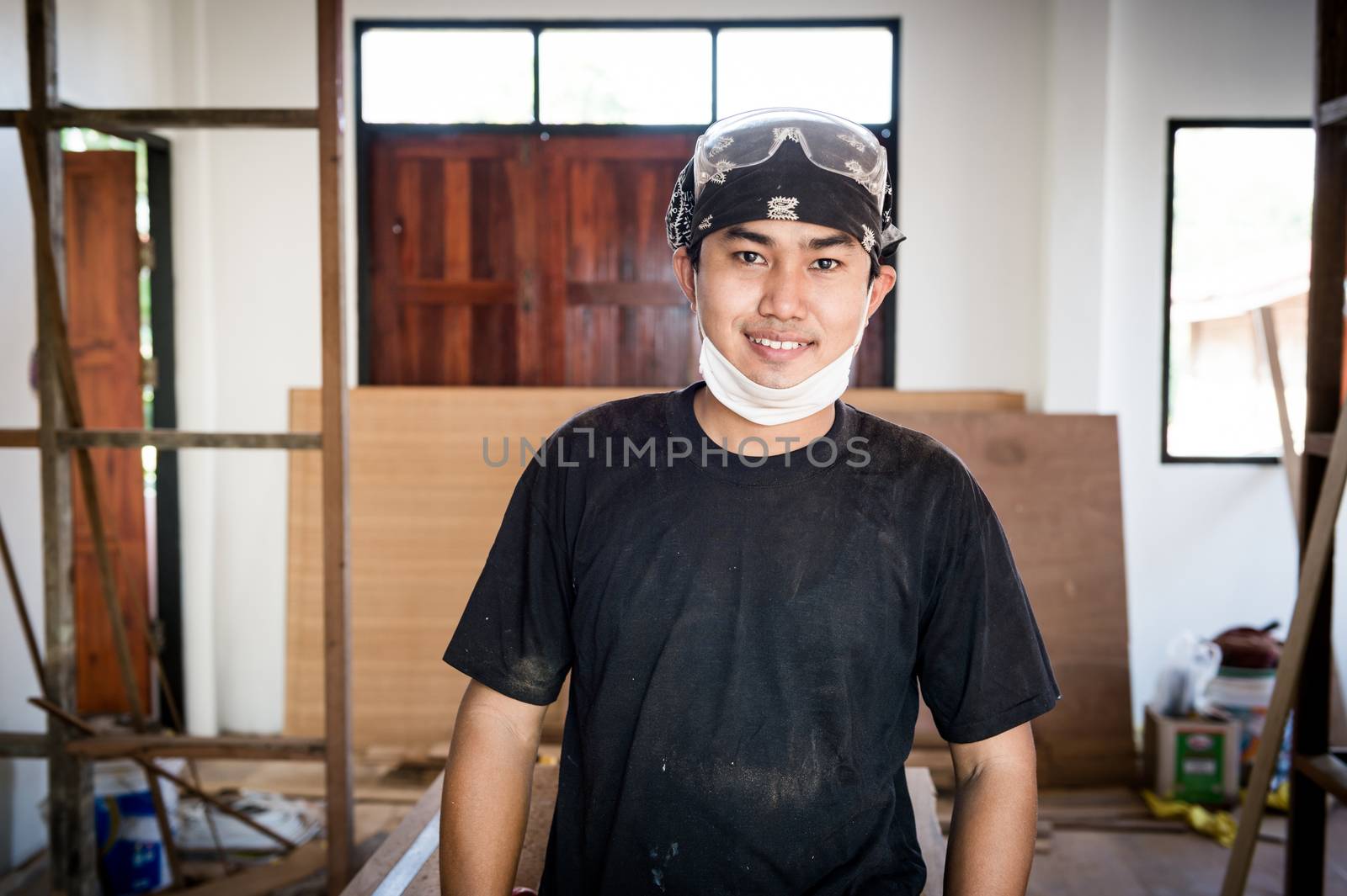 Young male carpenter portrait in workshop interior