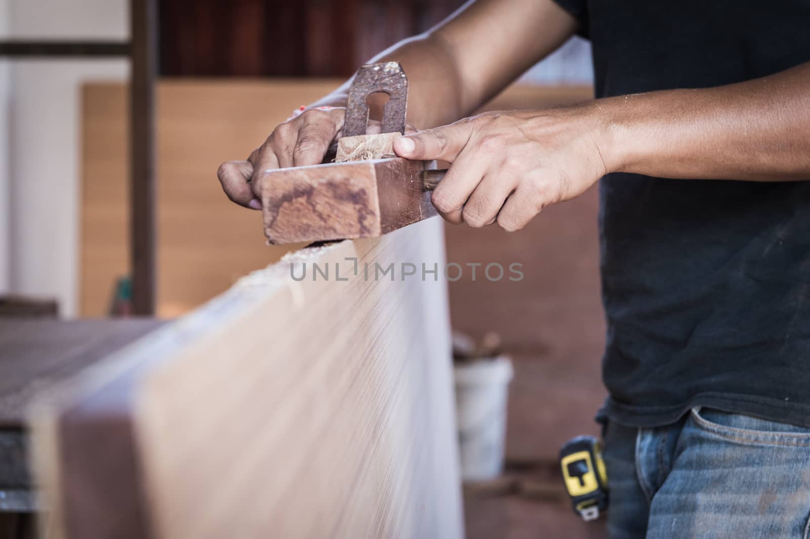 closeup of a hand take a planer tool with wood