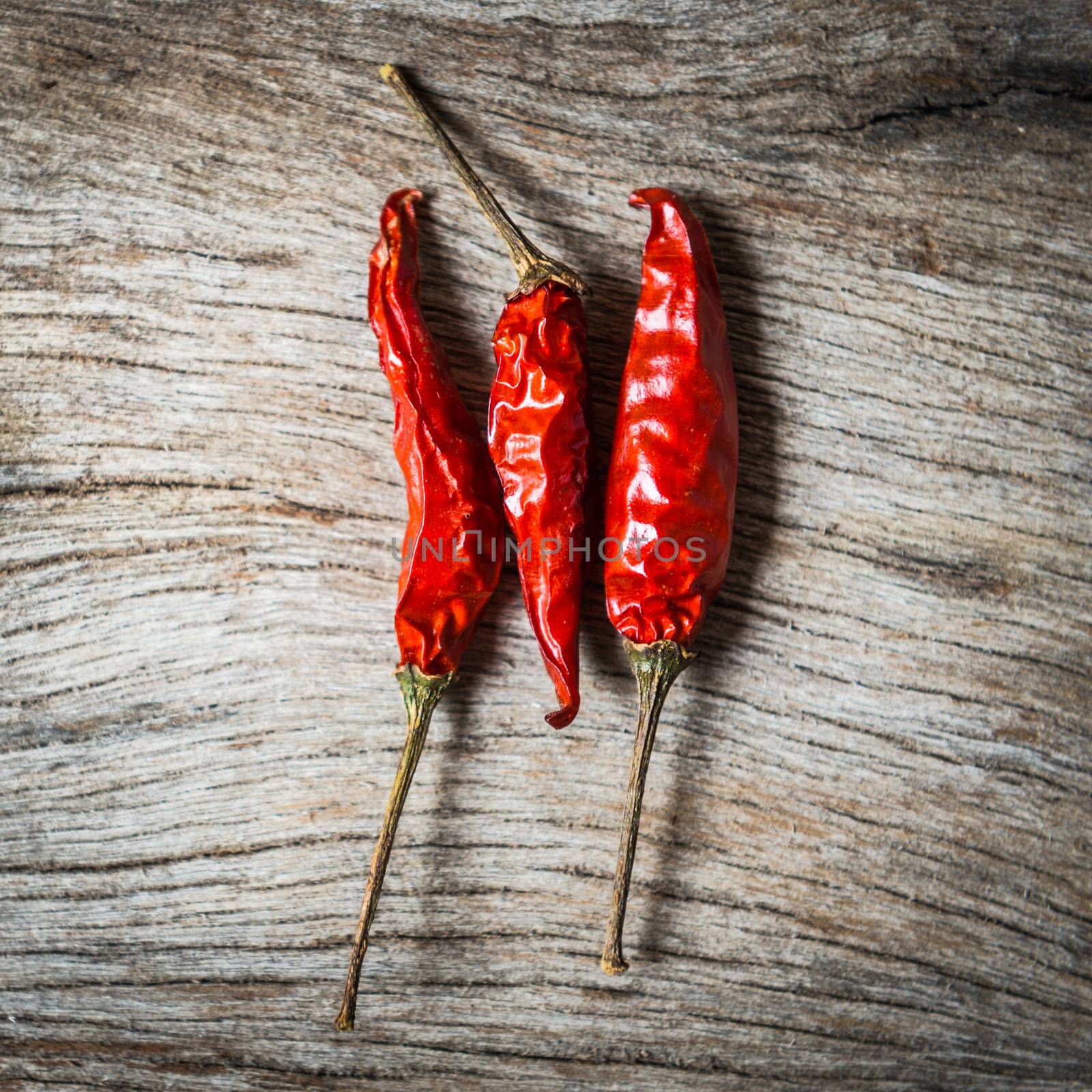 red chilli on wooden background by sayhmog