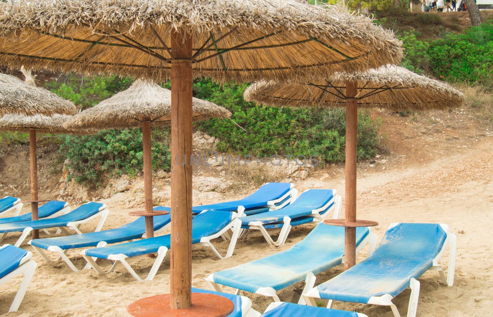 Chaise Lounges and straw umbrellas on the beautiful sandy beach of Palma de Mallorca by claire_lucia