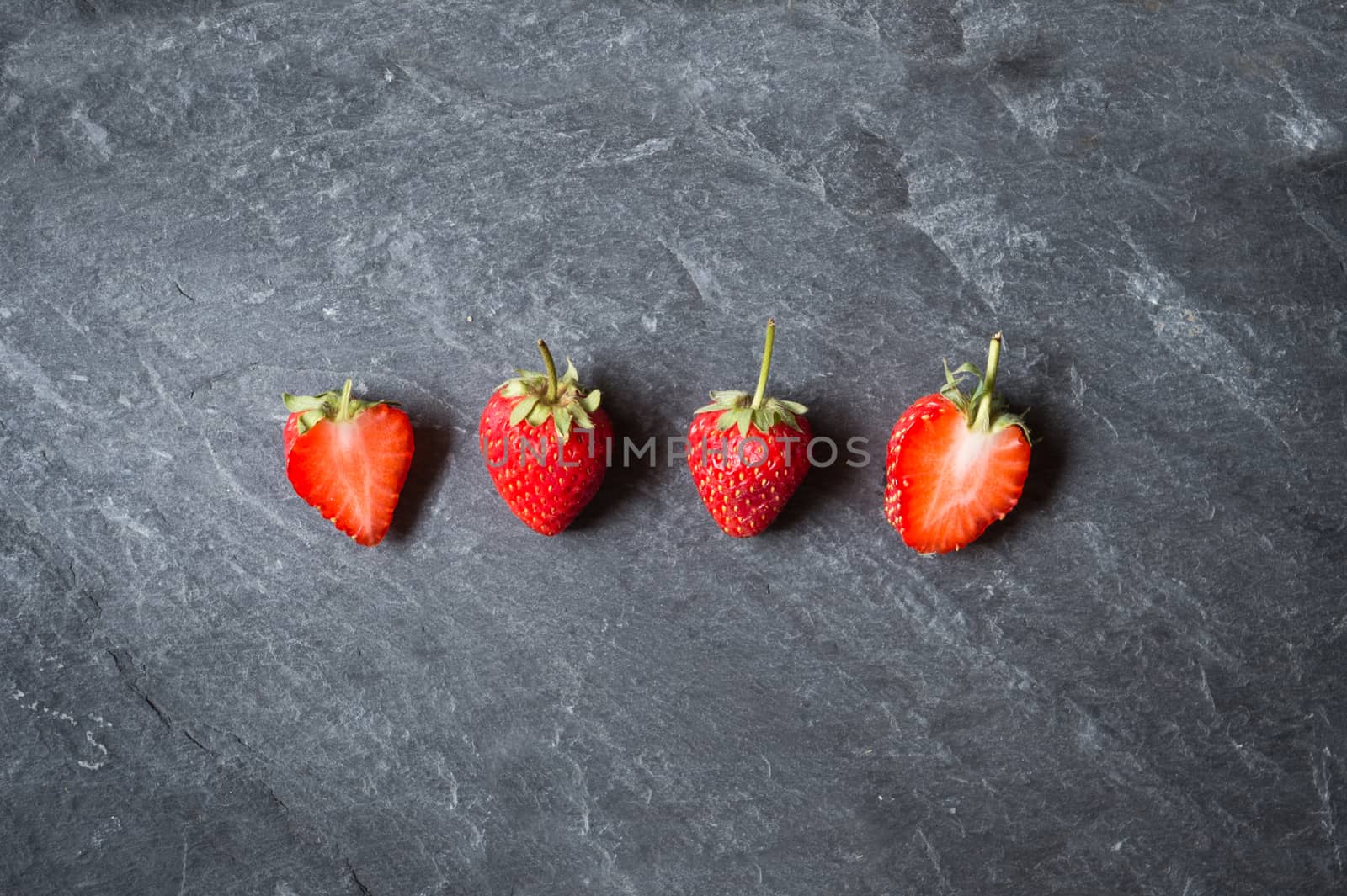Strawberry fruit on black stone background
