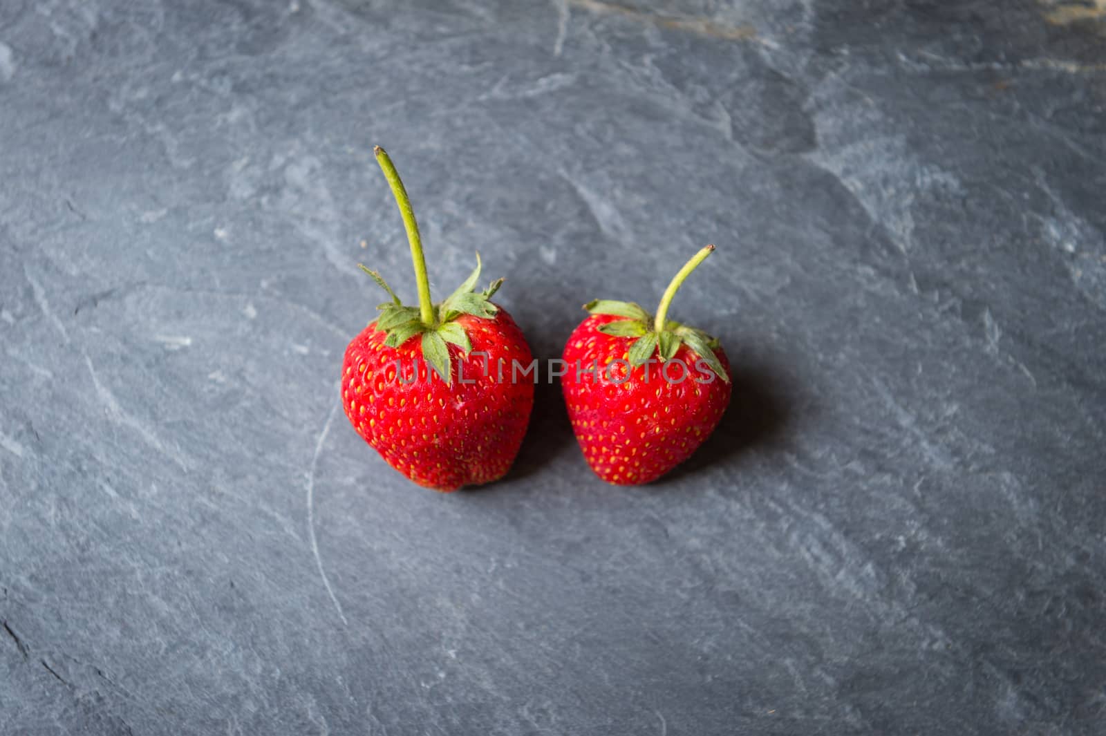 Strawberry fruit on black stone background
