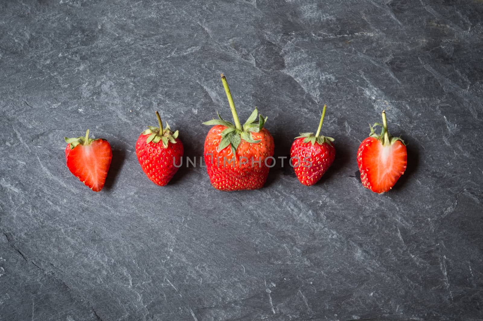 Strawberry fruit on black stone background