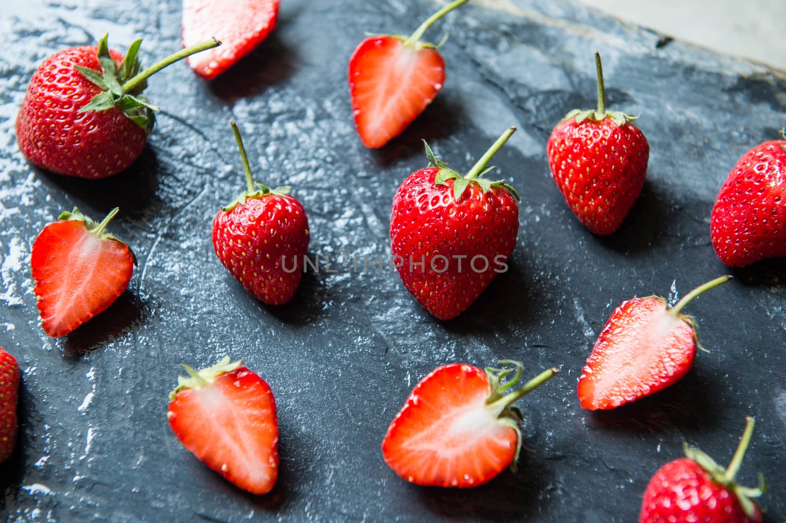 Strawberry fruit on black stone background