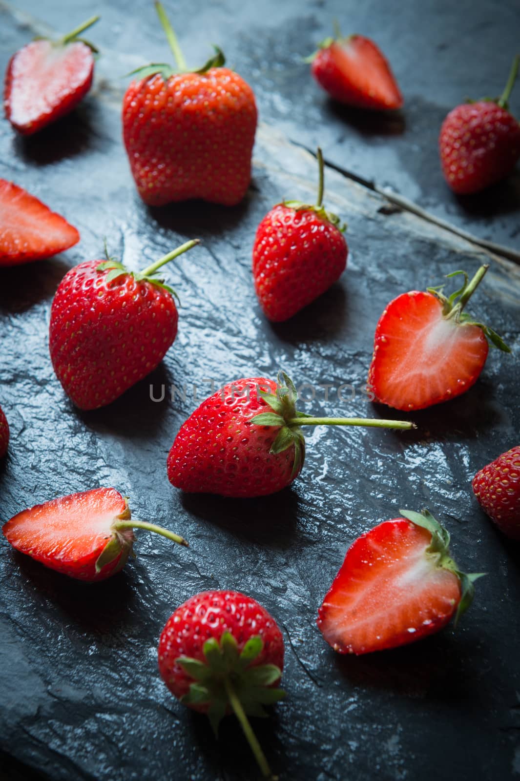 Strawberry fruit on black stone background