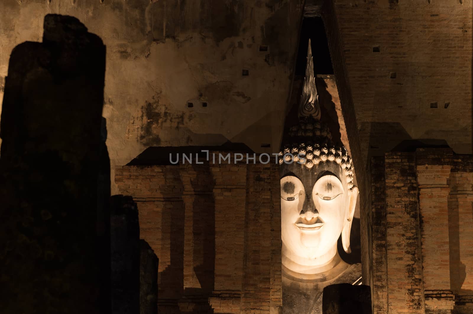 Closeup of Pra AdJaNa face buddha sculpture from Wat Si Chum, Sukhothai historical park, Thailand