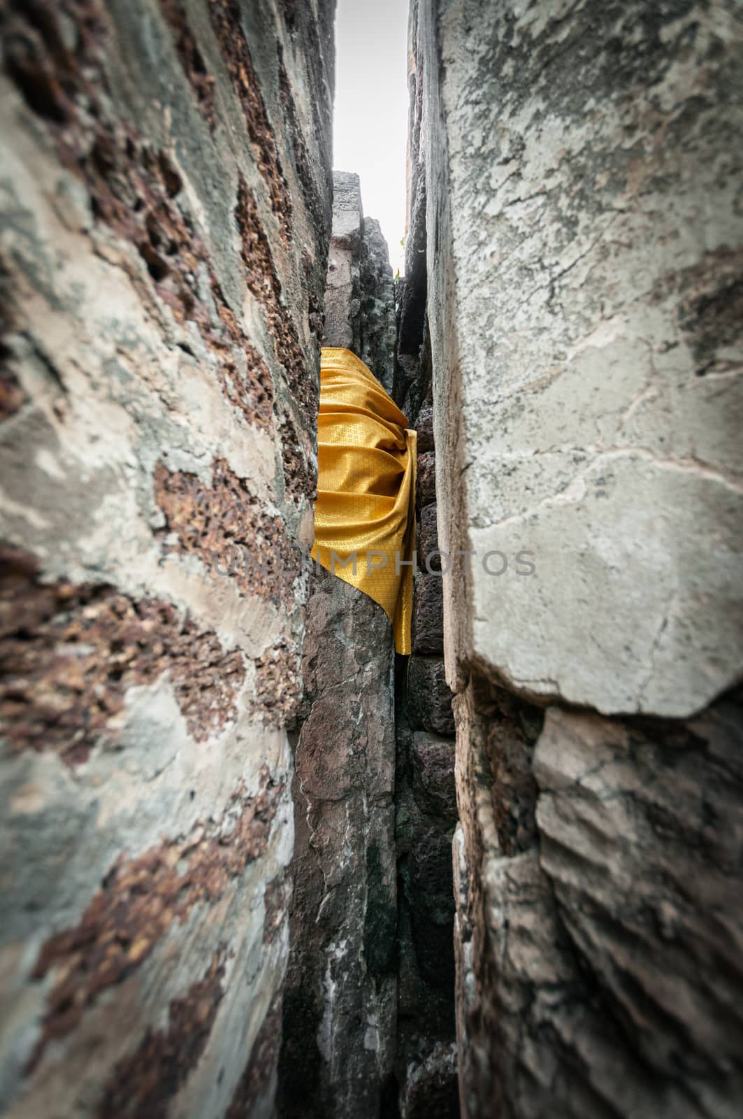 Closeup yellow fabric bind of stone wall, Traditional buddhism style in temple