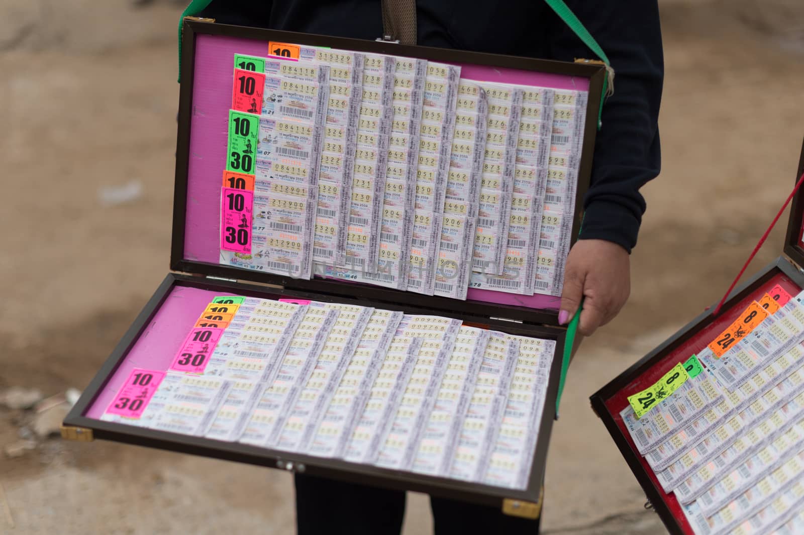 Closeup of Thai lottery ticket with seller
