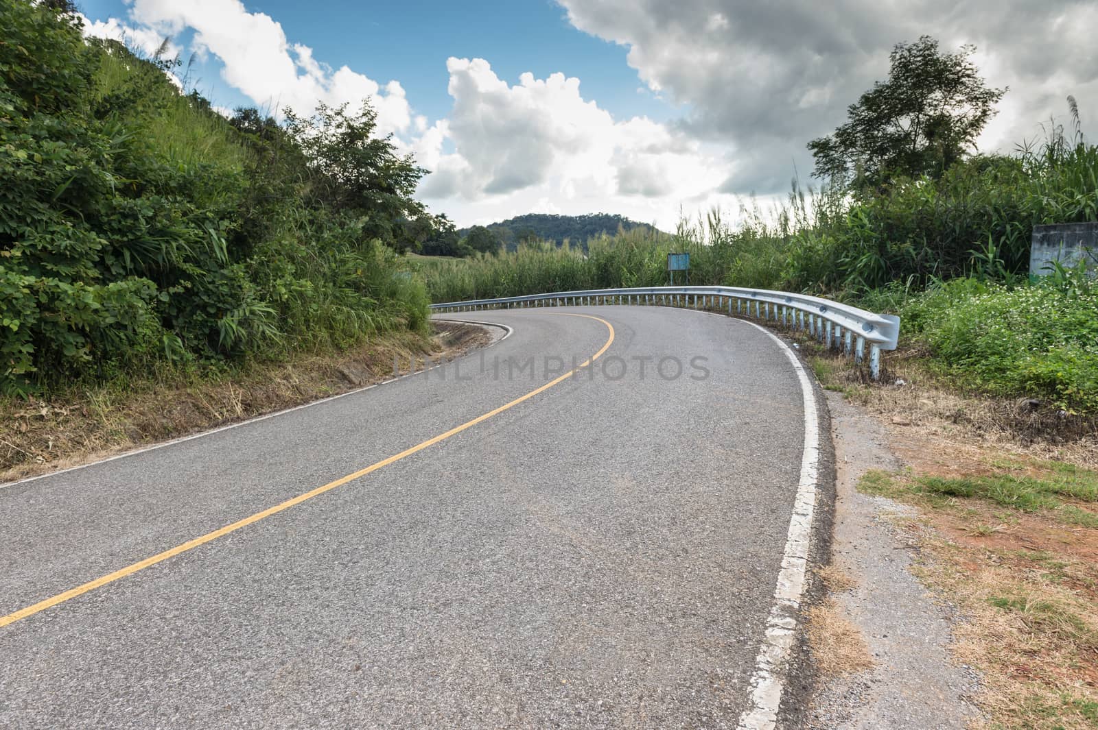 Road on mountain with clouds sky