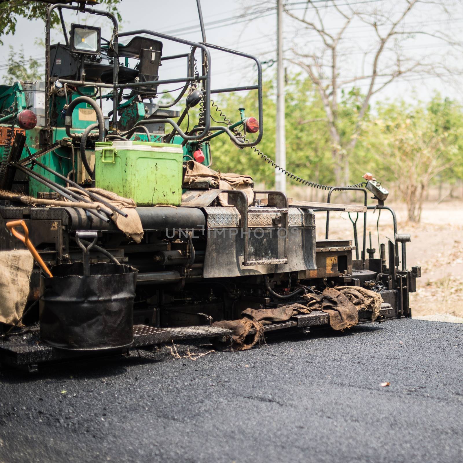 Closeup of grunge asphalt paving machines by sayhmog