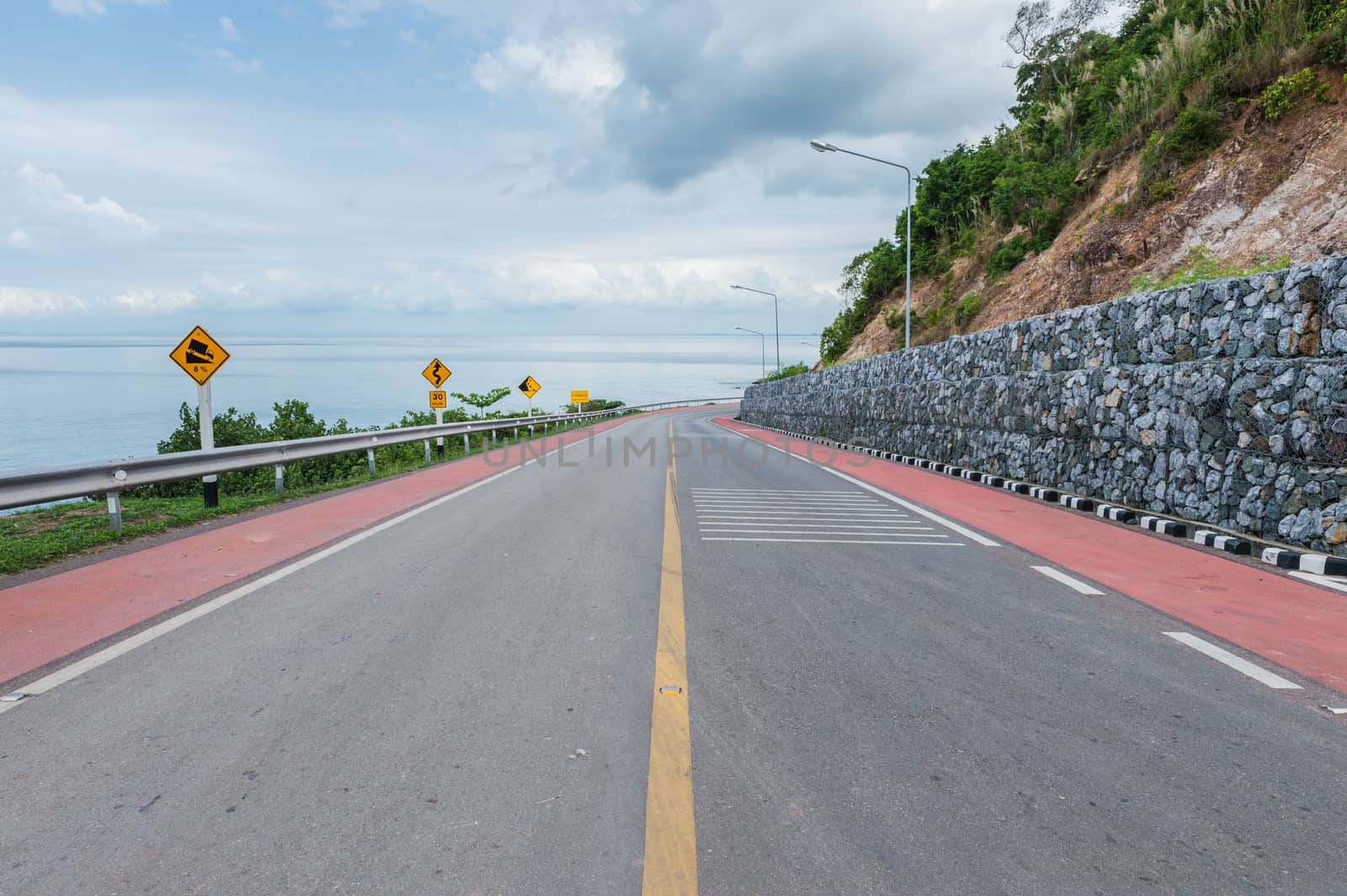 Lane of asphalt road with the ocean landscape by sayhmog