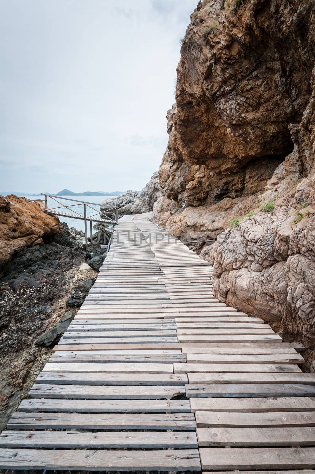 Wooden pathway with rock valley or cliff on the island