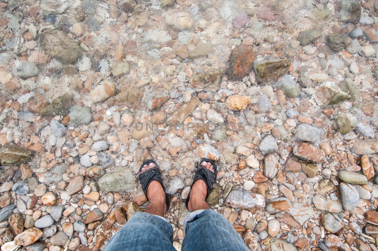 Closeup of human's leg with pebble beach