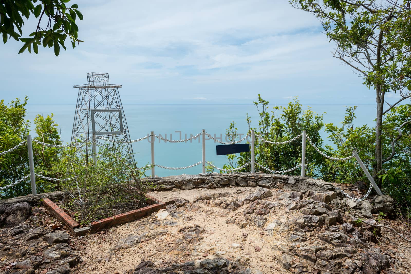 Closeup of metal fence on the hill with ocean landscape