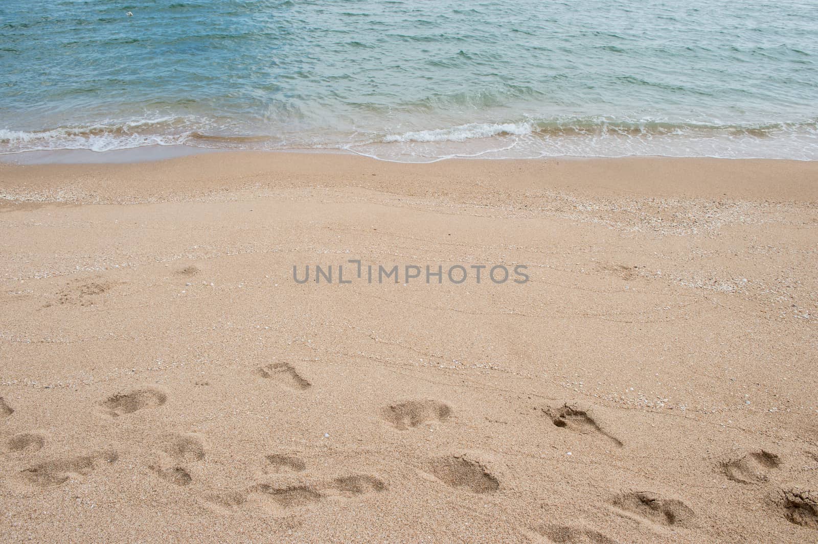 Background of footprint on the beach with sea wave by sayhmog