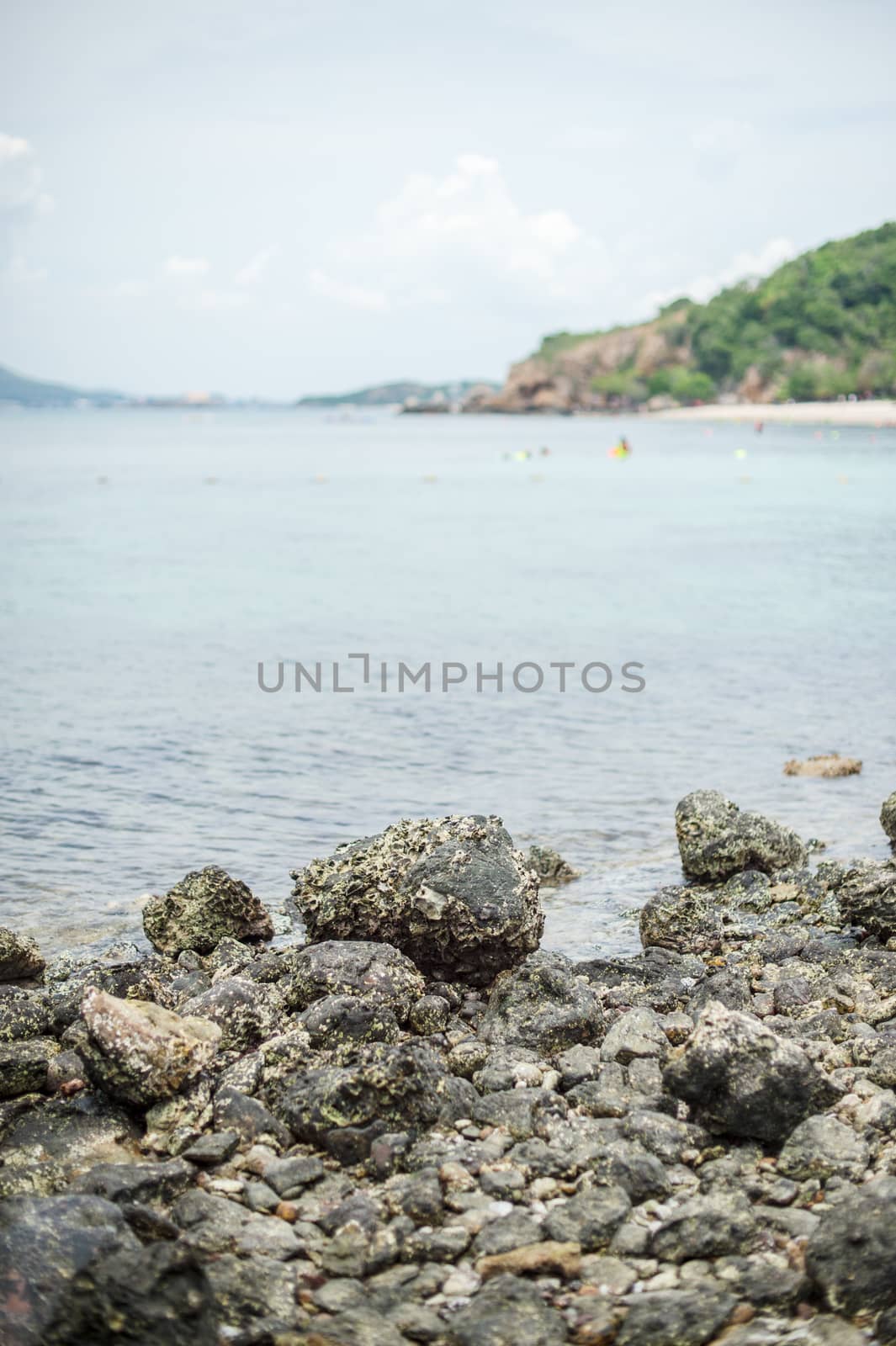 Closeup of stone on sea beach with clouds sky landscape