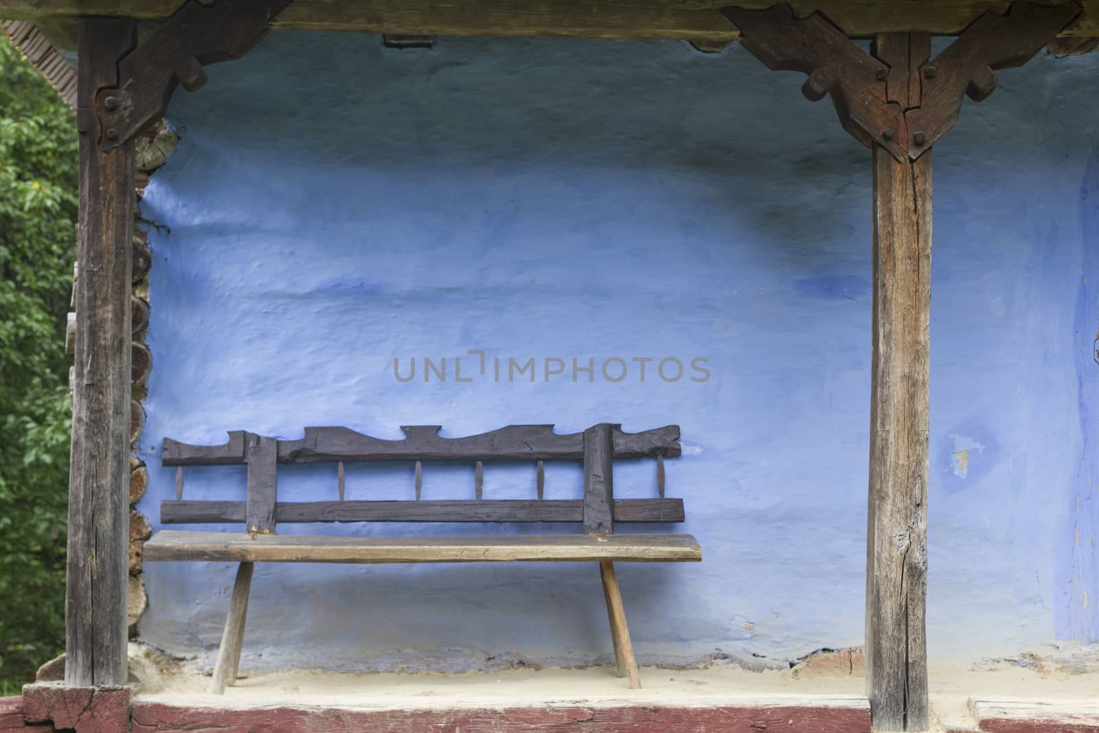 Old Wood Bench with Blue Log House