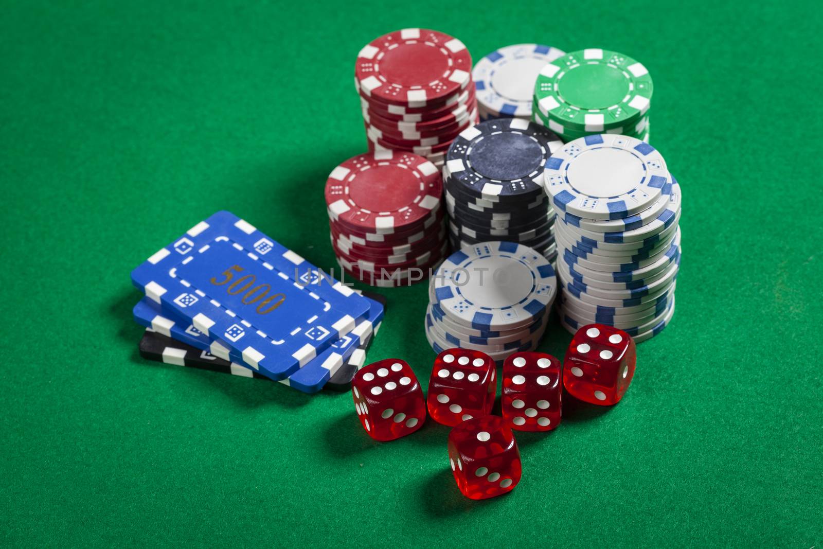 Square and Round Casino Chips With Red Dice on Green Table