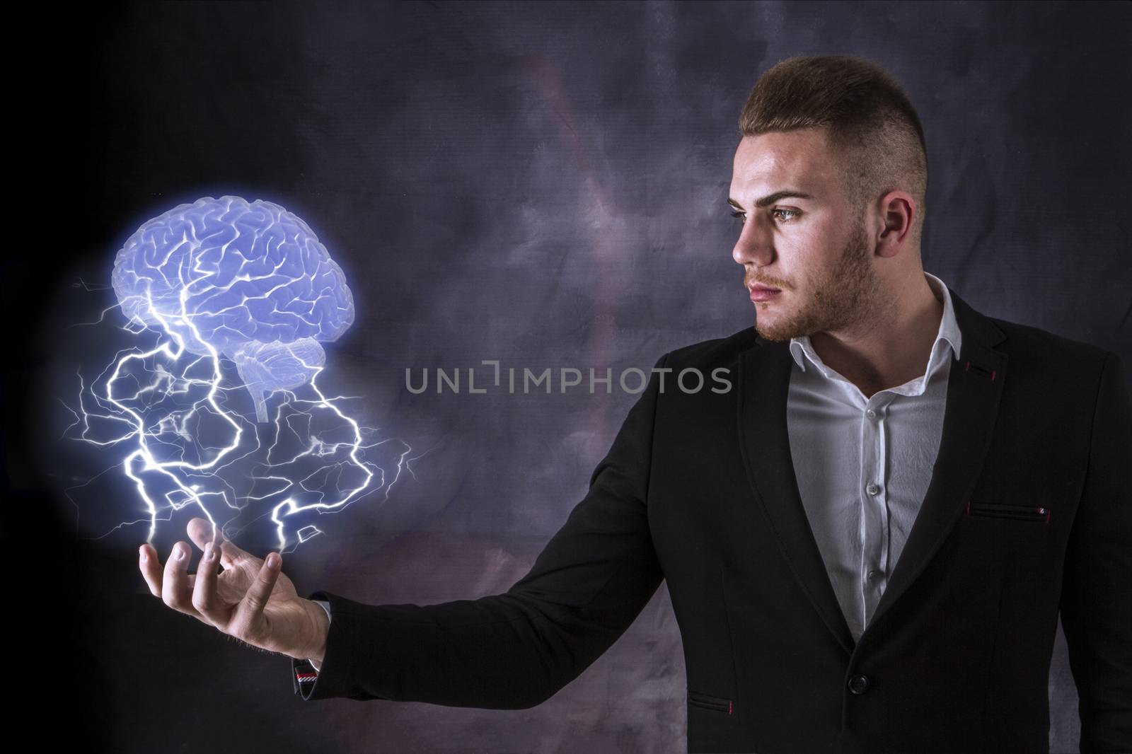 Business Man holding a brain in lighning