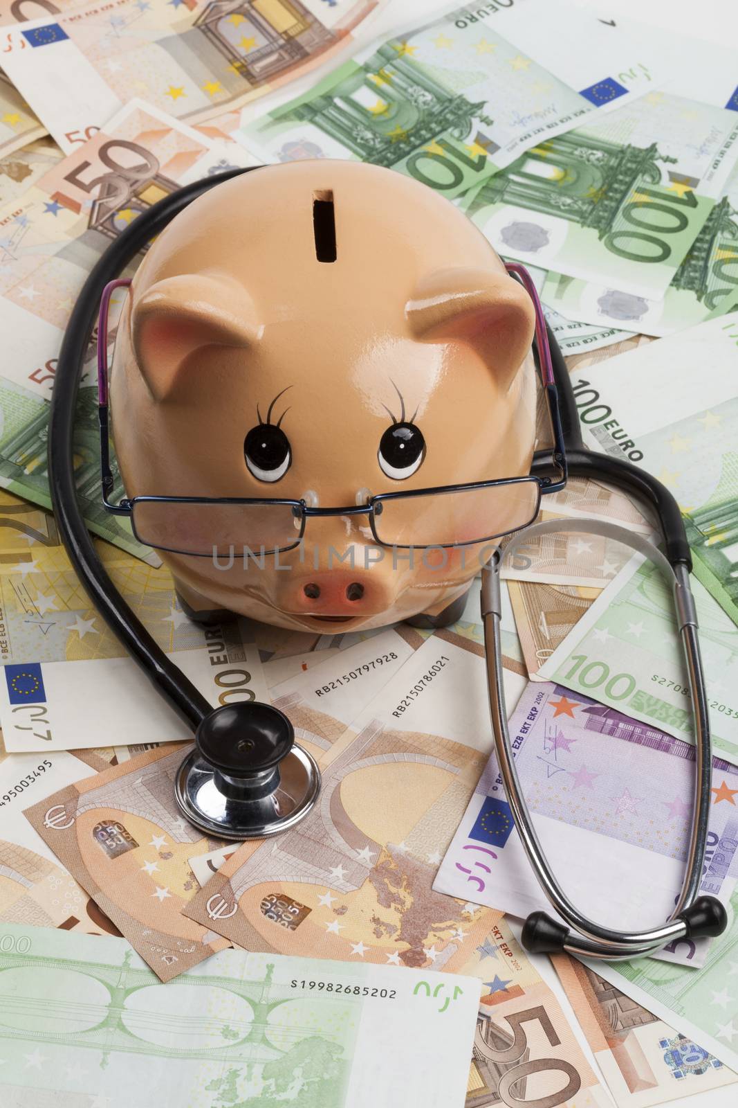 Piggy Bank With Black Stethoscope on Euro Banknotes . European Health Insurance Costs