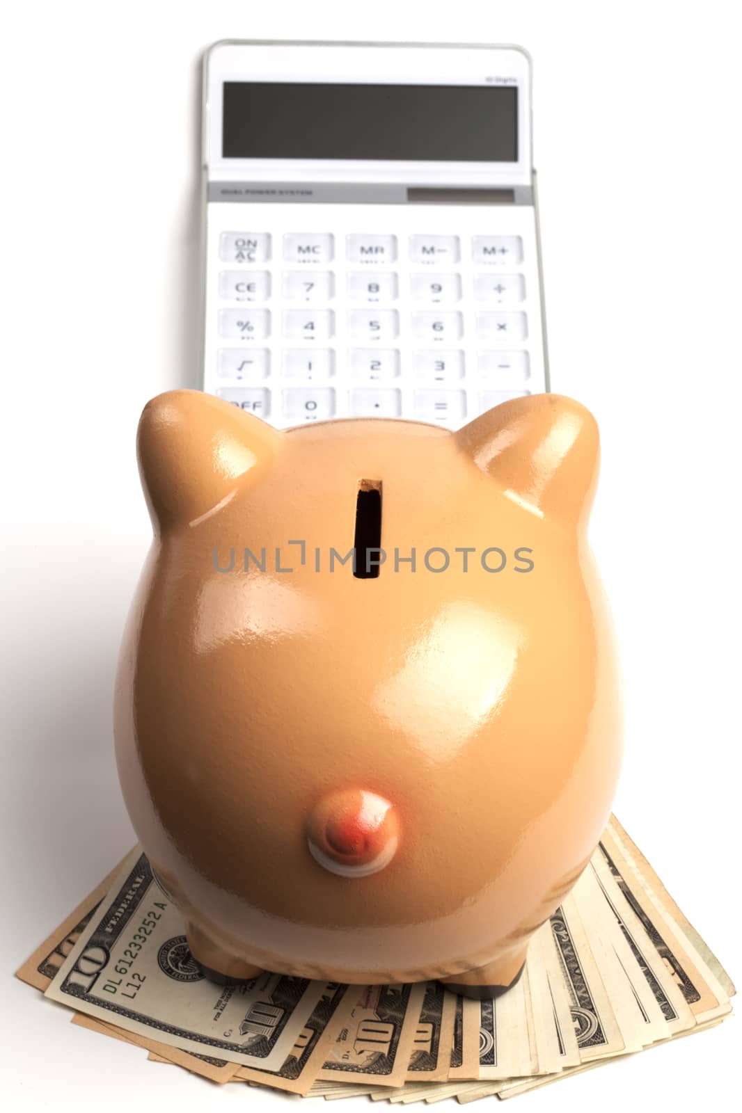 Piggy Bank On Dollars and Calculator Isolated on White Background