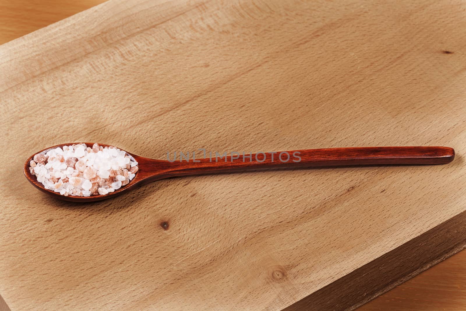 Brown Wood Spoon With Himalayan Pink Salt on Wood Cutting Board