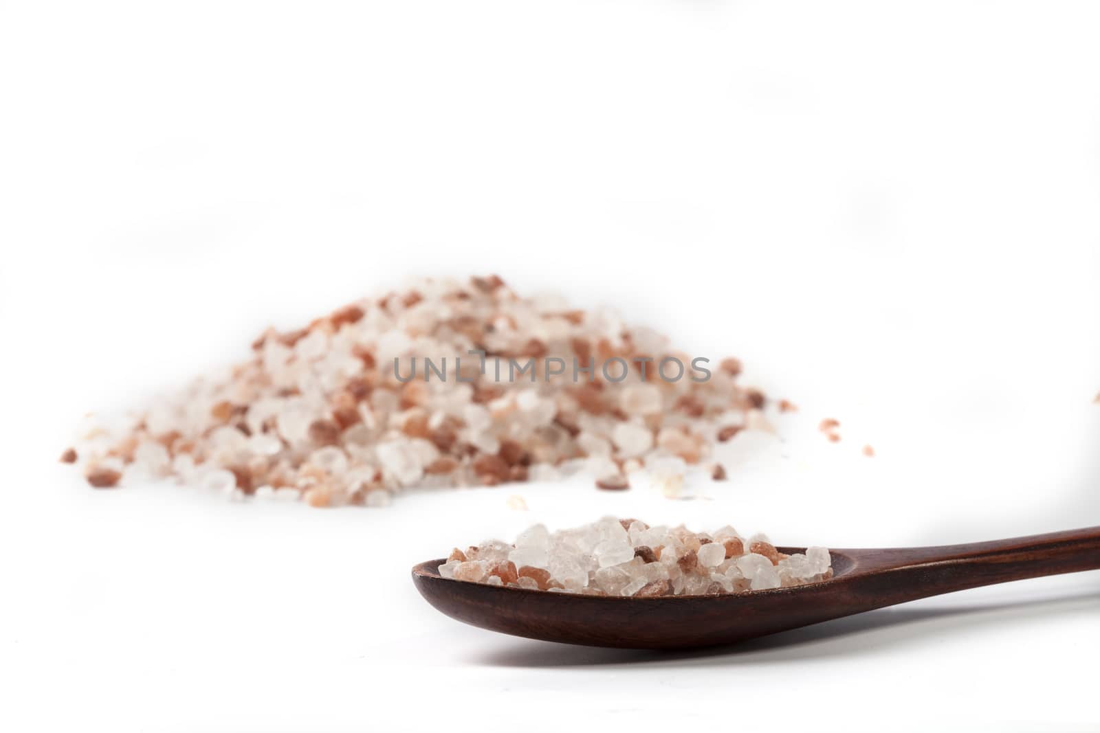 Himalayan Salt Raw Crystals Pile with Brown Wood Spoon Isolated on White Background