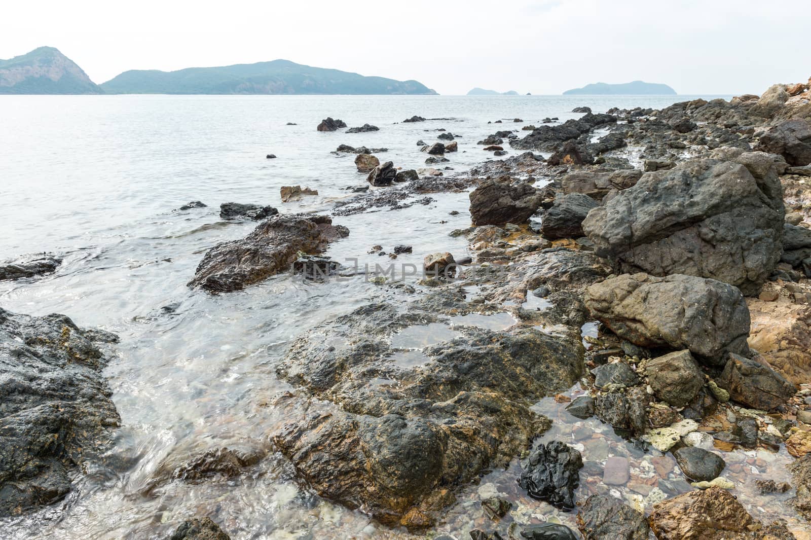 Abstract stone on the beach with mountain landscape