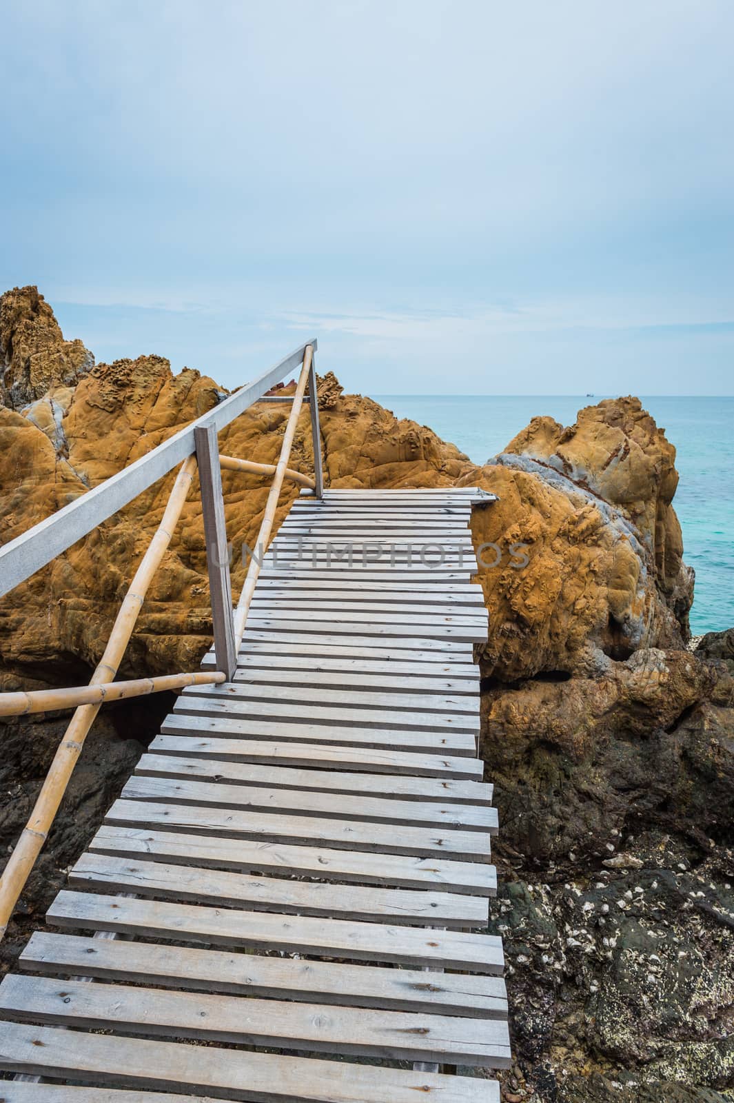 Wooden pathway with rock valley or cliff on the island