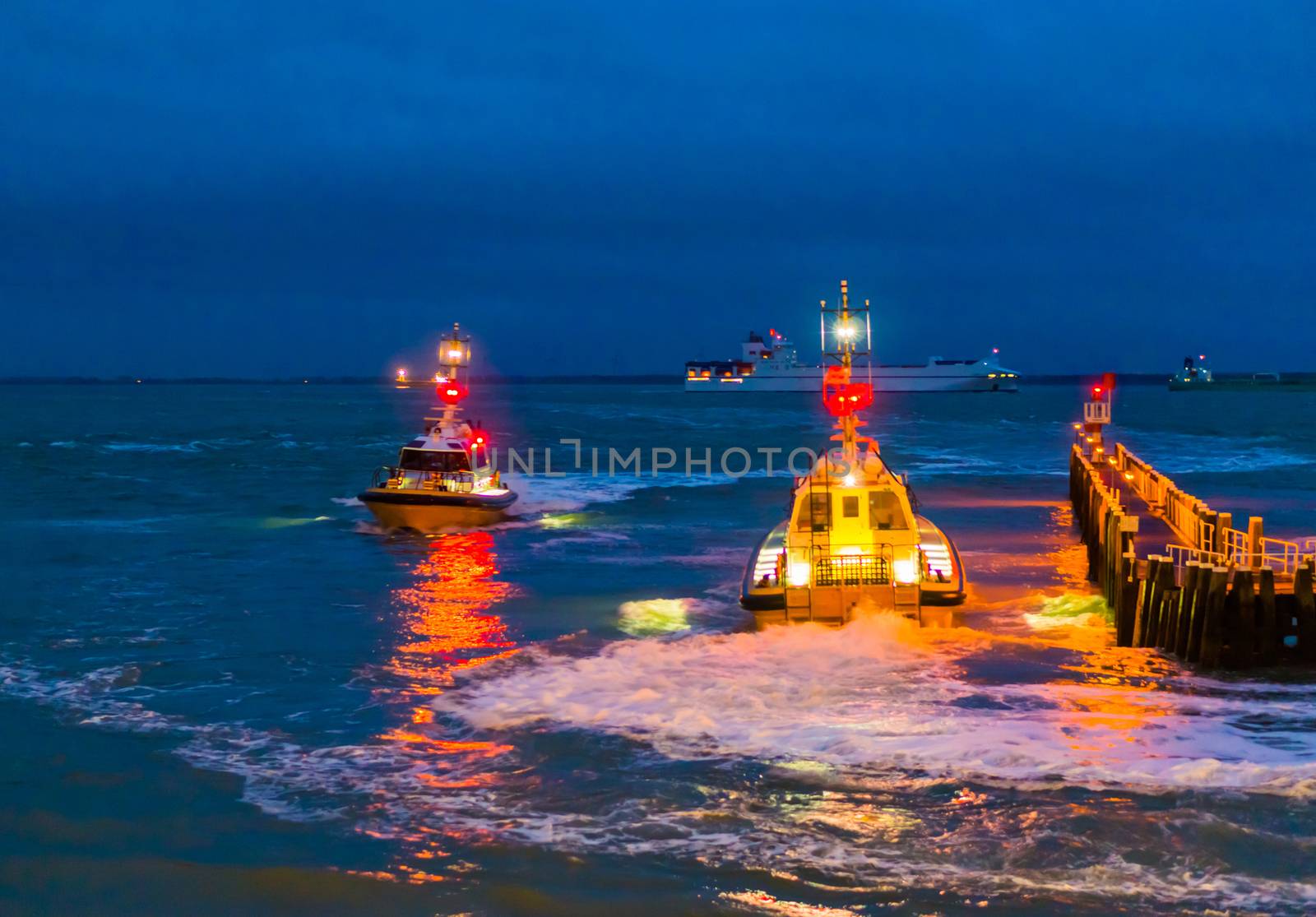 lighted boats sailing at night in the port of Vlissingen, The pier jetty in the evening, Zeeland, The Netherlands