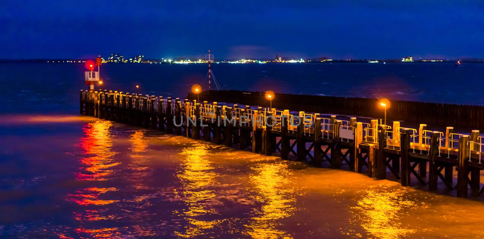 The pier jetty of vlissingen illuminated at night, lights reflecting in the ocean, Zeeland, the netherlands