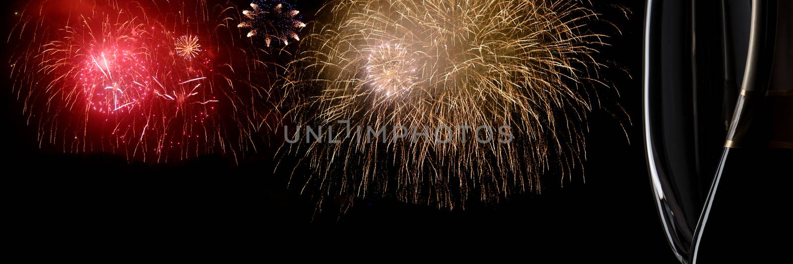 Image of two champagne glasses and fireworks