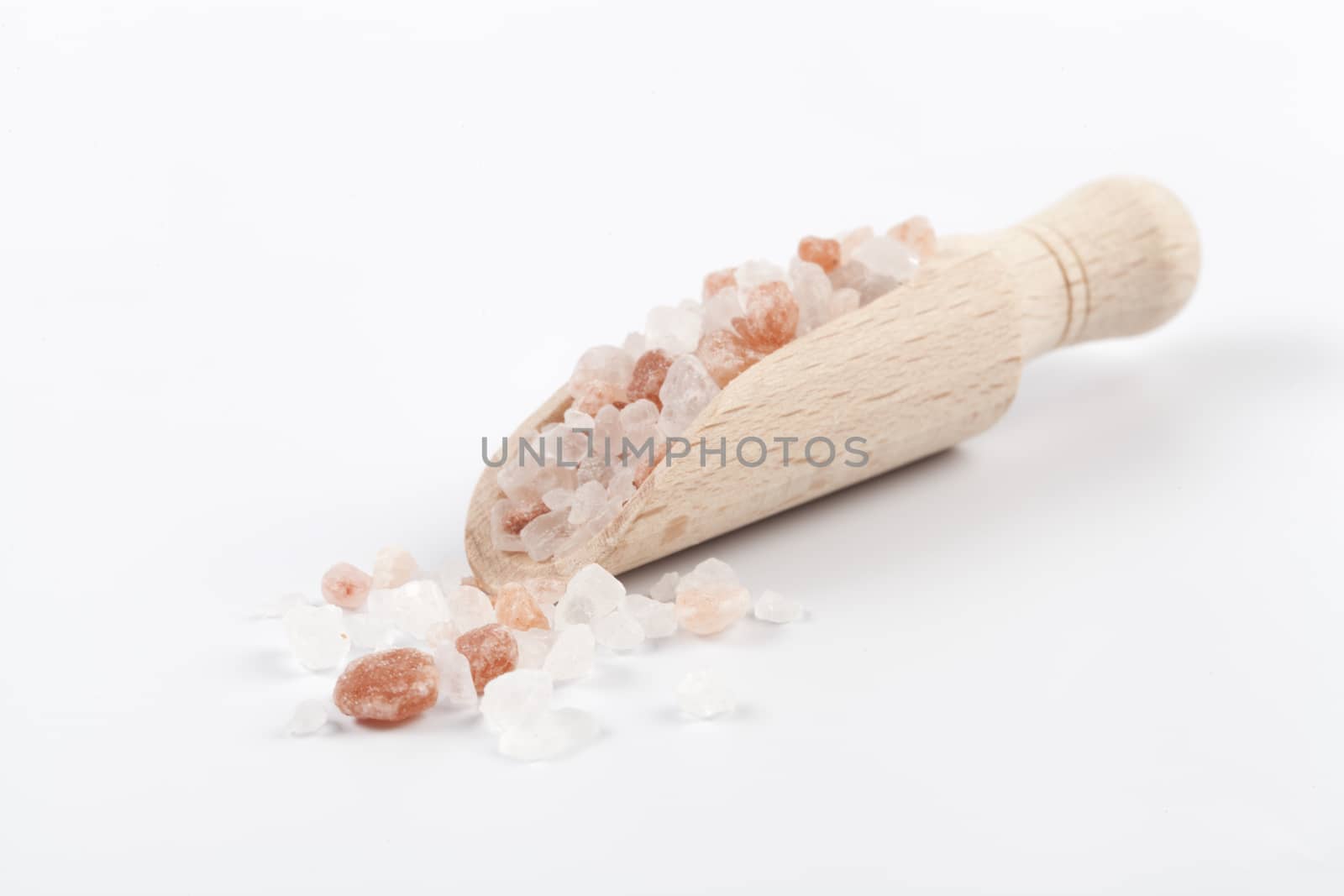 Himalayan Salt Raw Crystals Pile with Brown Wood Spice Scoop Isolated on White Background