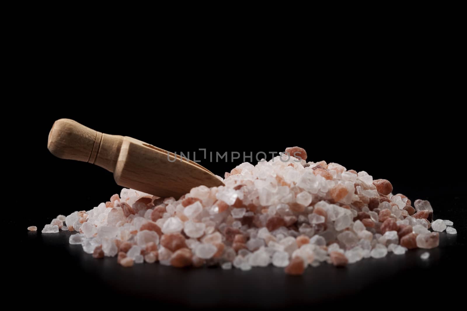 Broen Wood Spice Spoon On Salt Crystals Isolated on Black Background