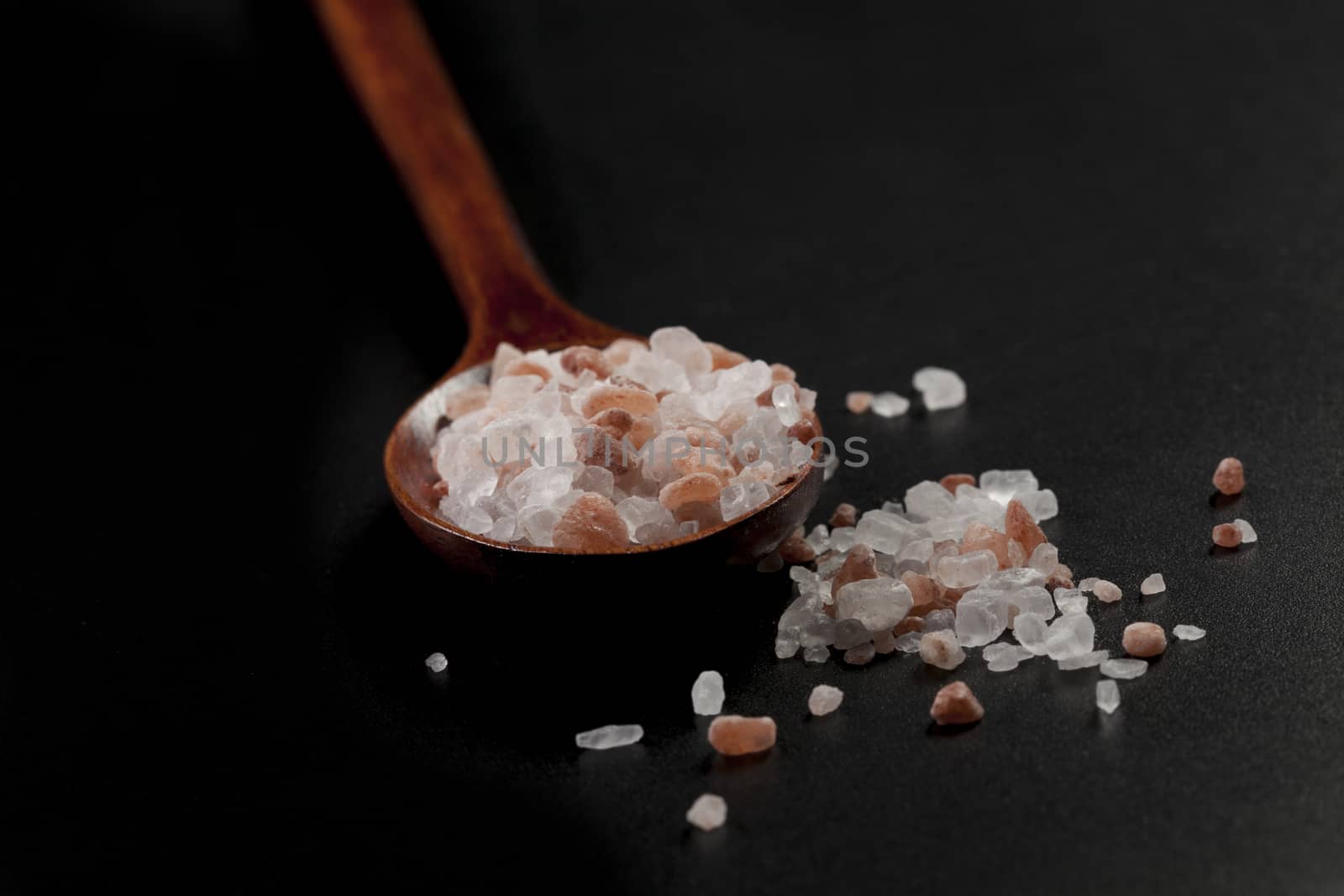 Rustic Wood Spoon With Himalayan Salt Raw Crystals on Dark Background