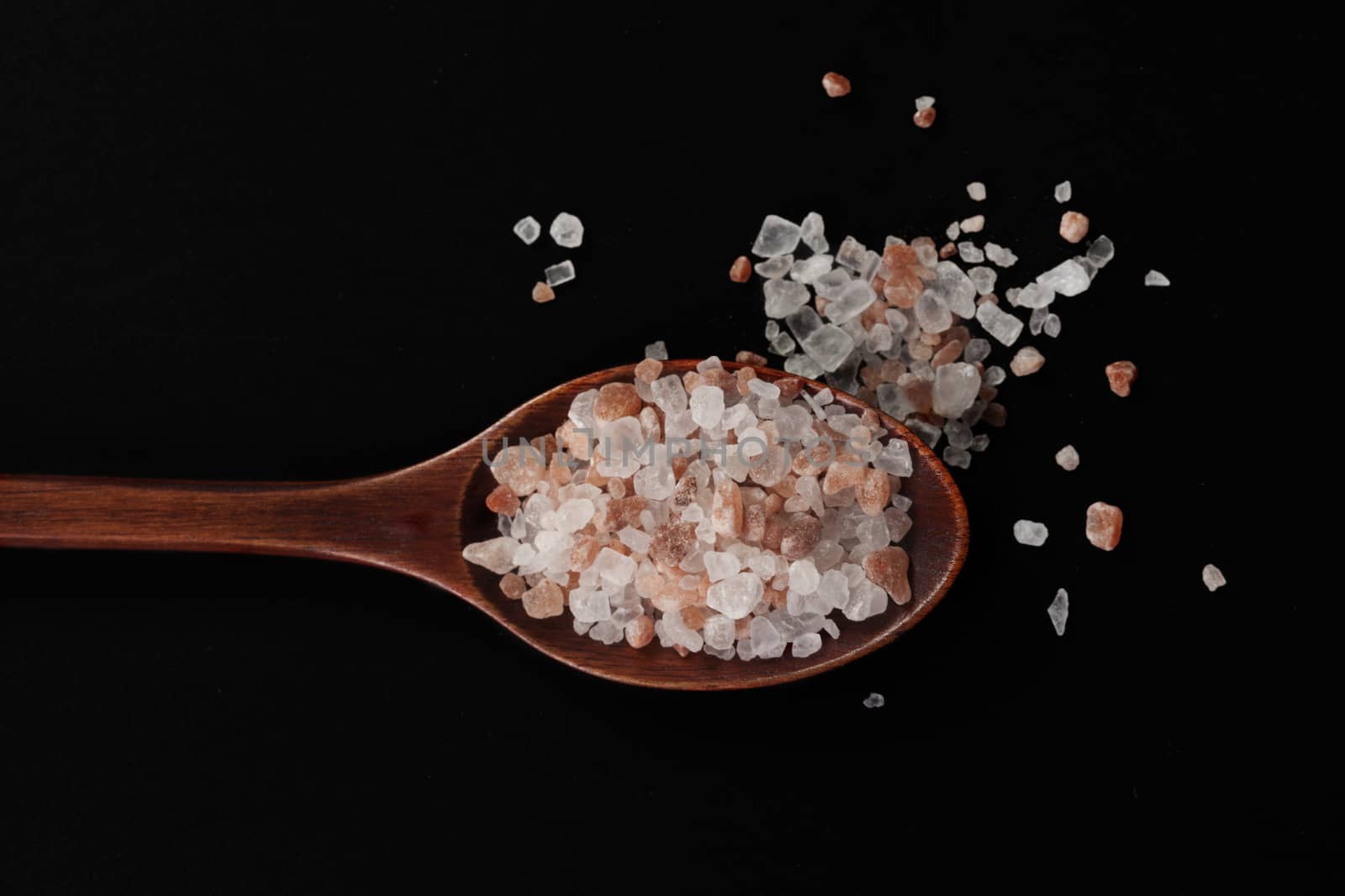 Rustic Wood Spoon With Himalayan Salt Raw Crystals on Dark Background