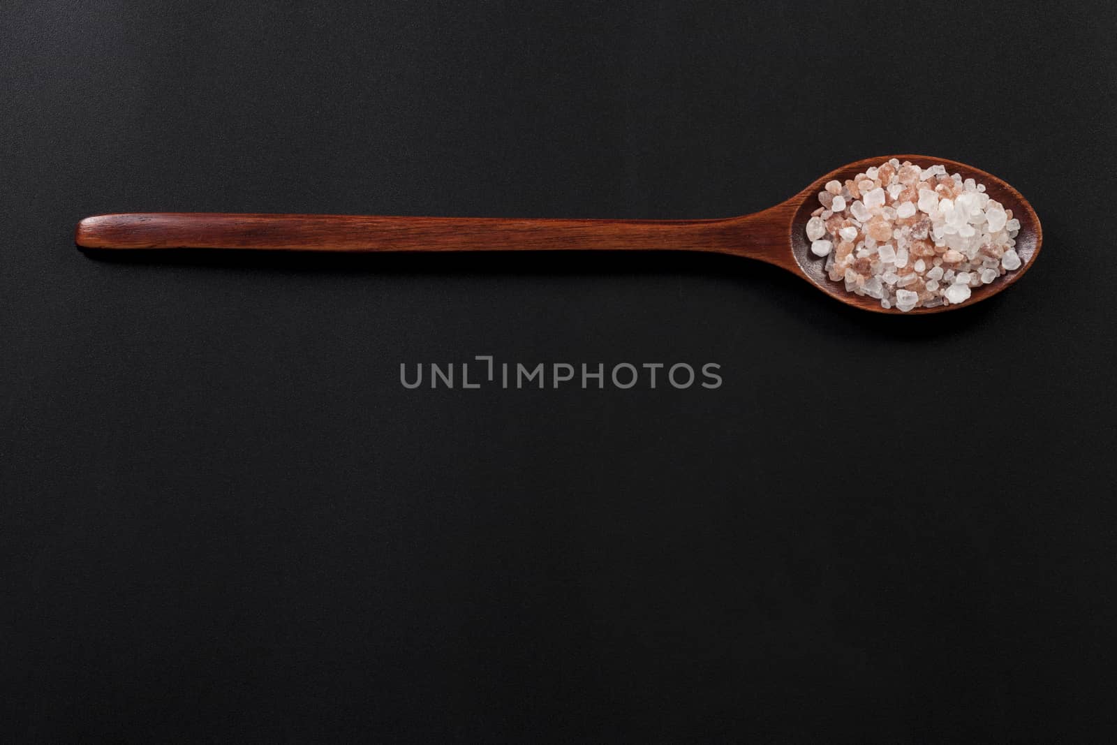 Wood Spoon Full With Himalayan Salt on Gray Background