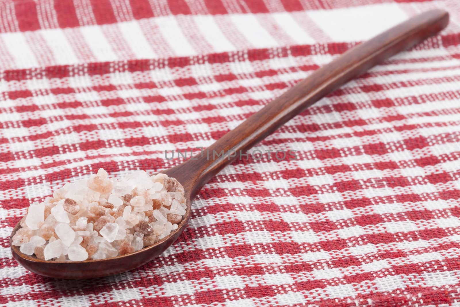 Himalayan Salt Raw Crystals in a Wood Spons on Red  Background