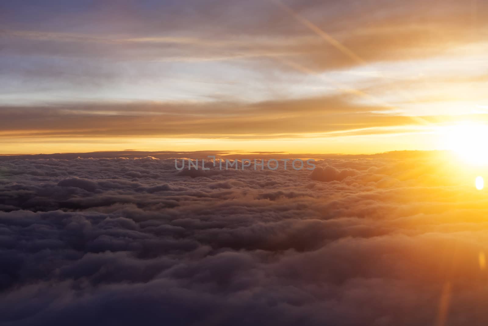 Sunrise over fluffy clouds with bright rays of light