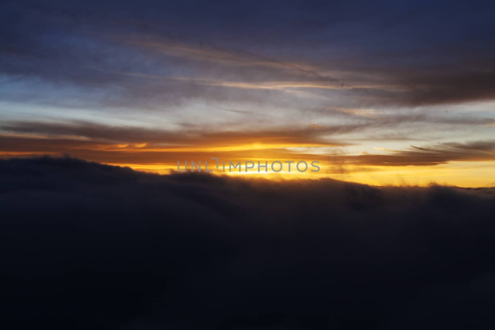 Dramatic Sunrise over fluffy clouds with bright rays of light