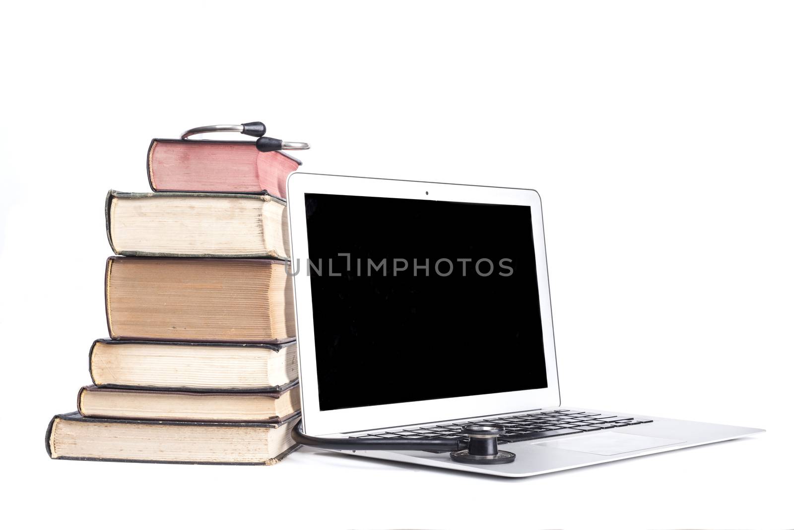 Silver laptop with black stethoscope and old pooks pile isolated on white background