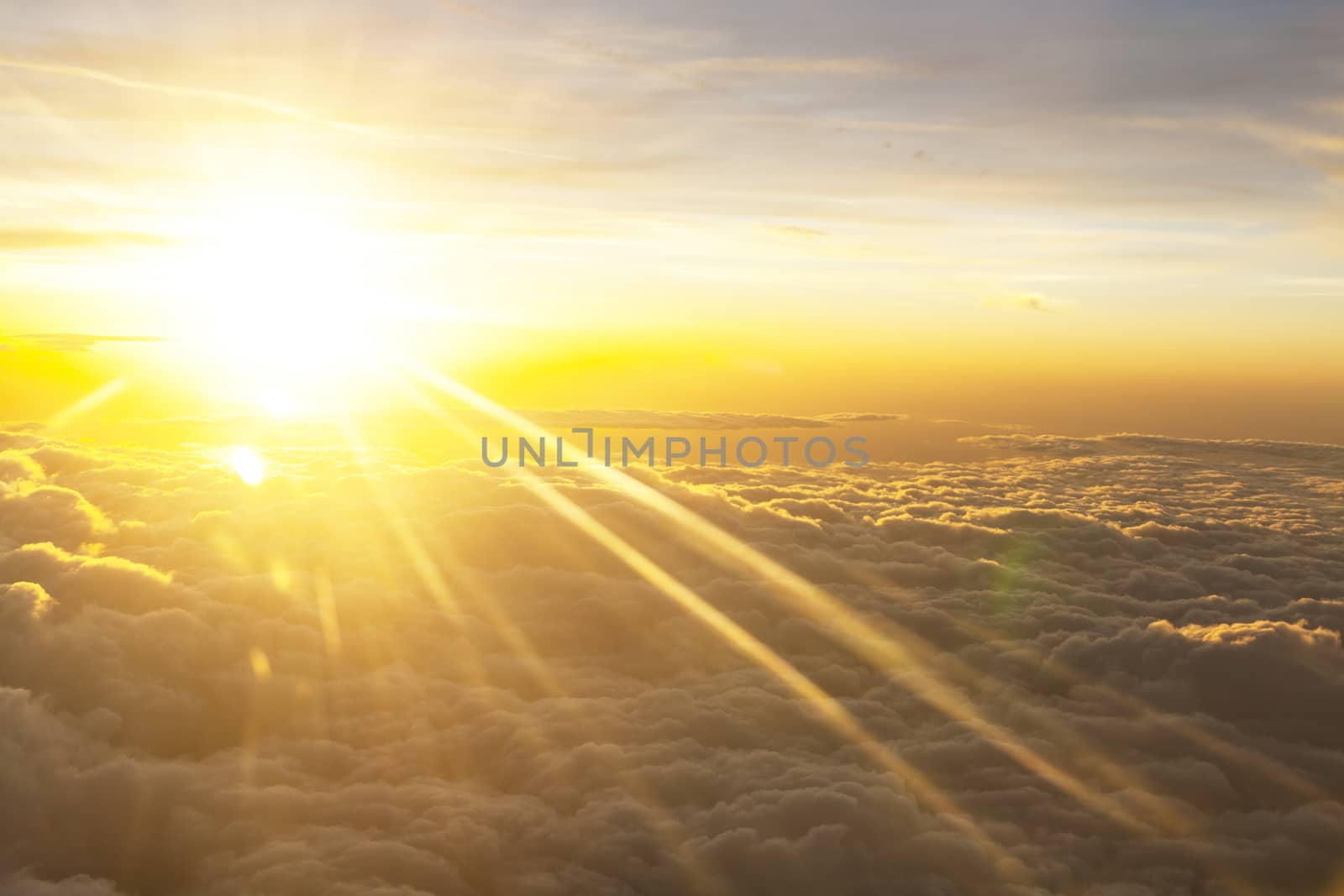 Sunrise over fluffy clouds with bright rays of light