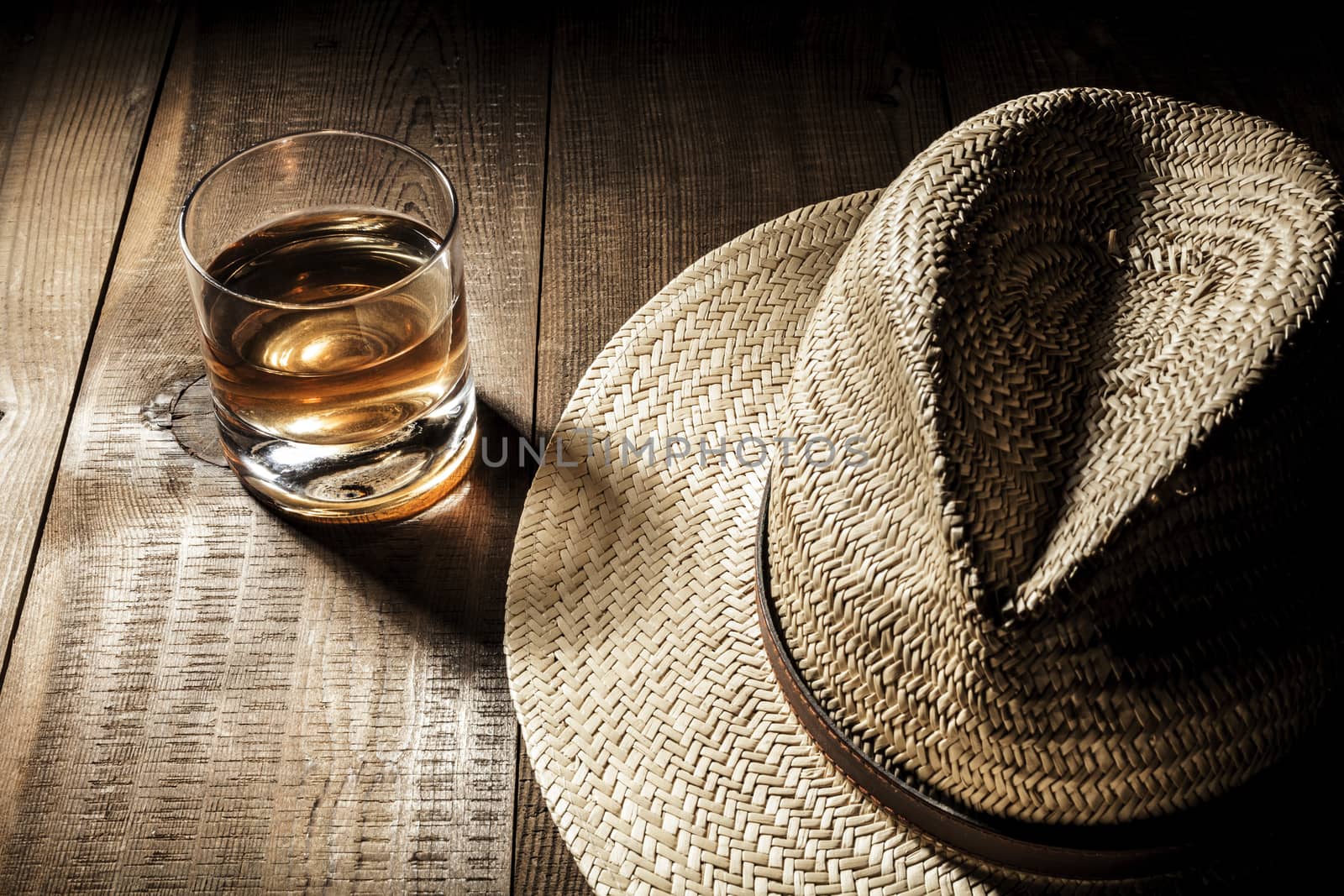 Alcohol and hat on table with shadow