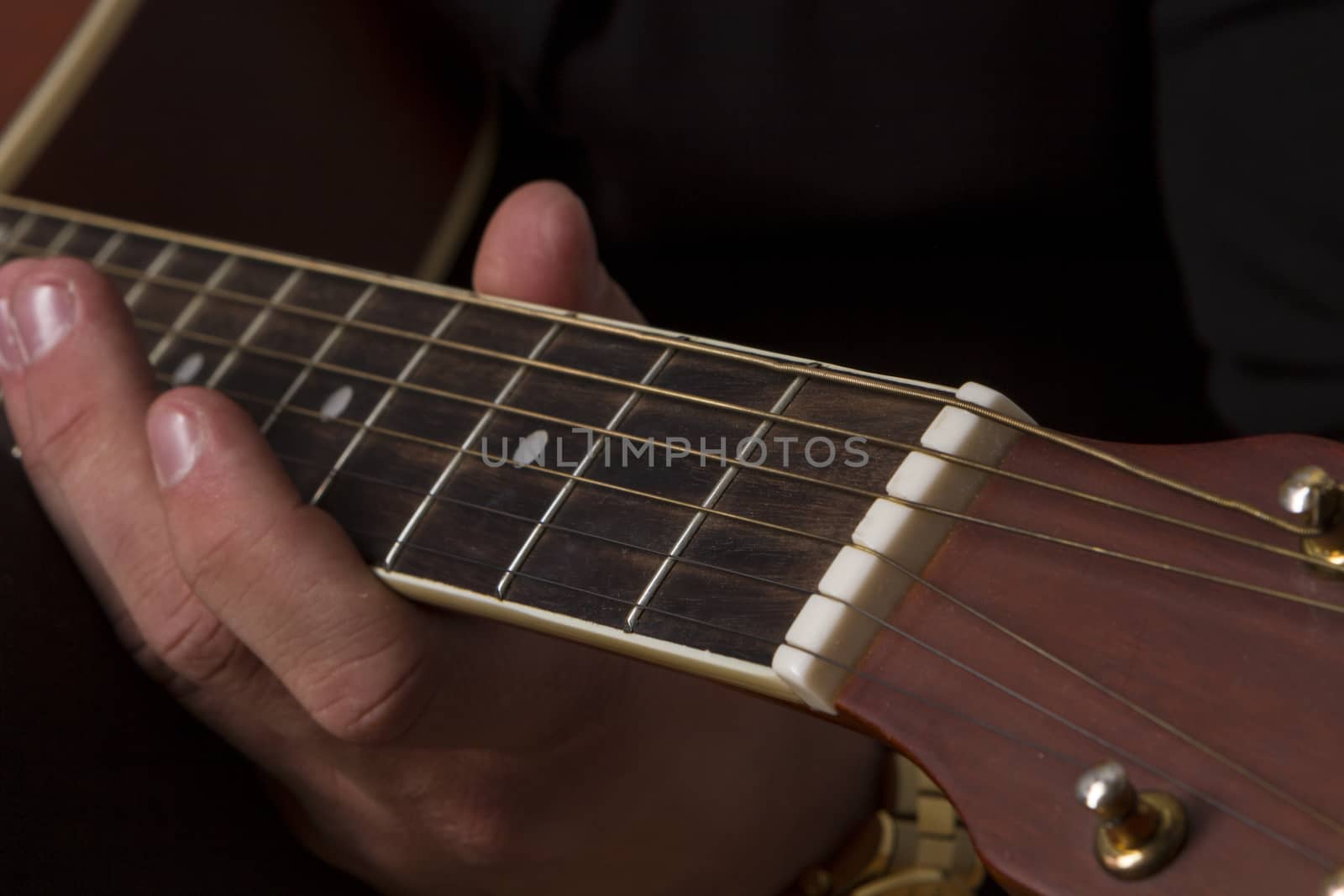 Young man playing clasic guitar with on dark Background