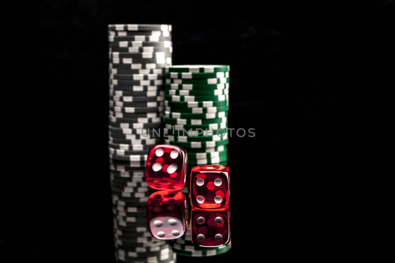 Dice and chips isolated on black background with reflexion