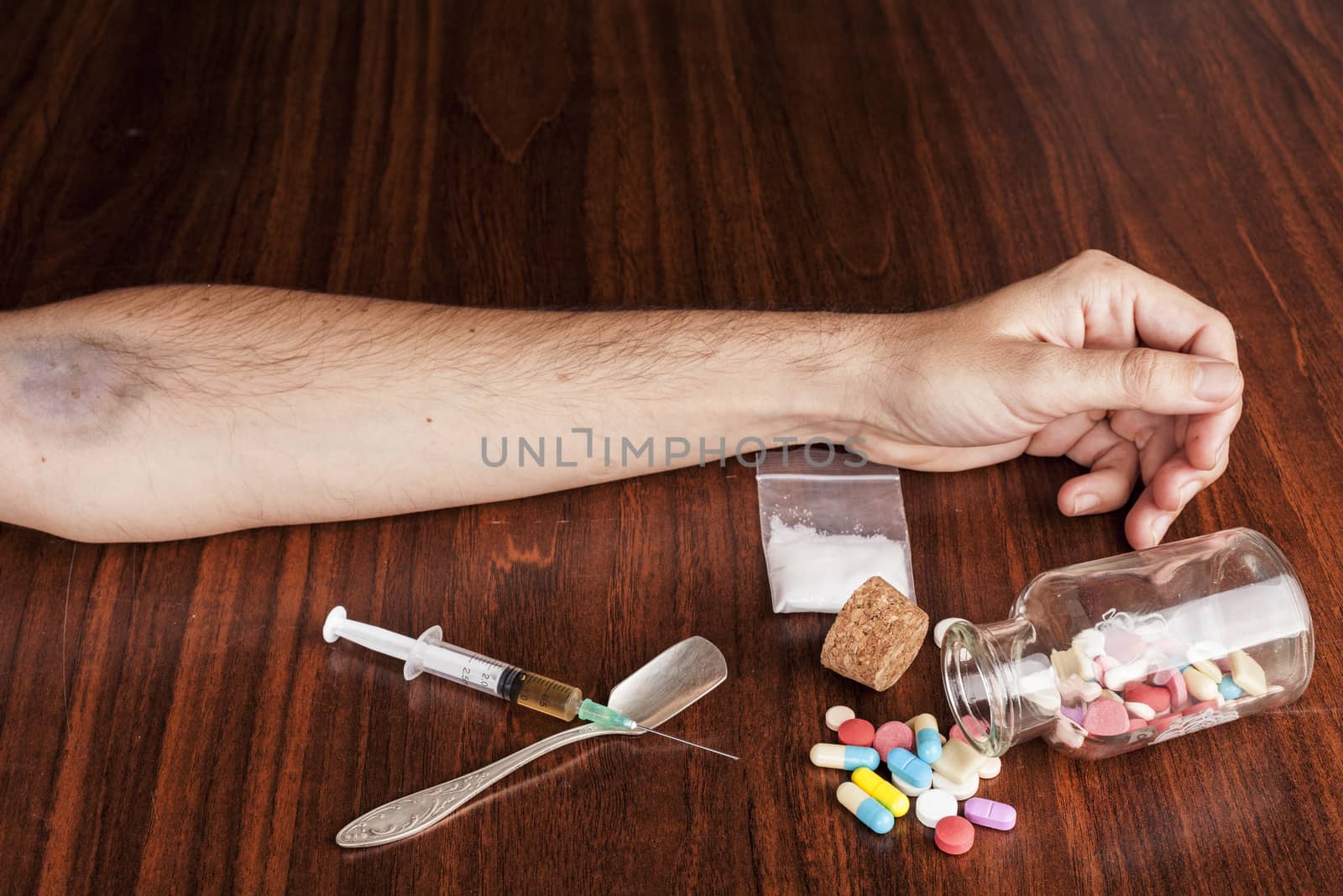 Hand with pills and drugs on wood table