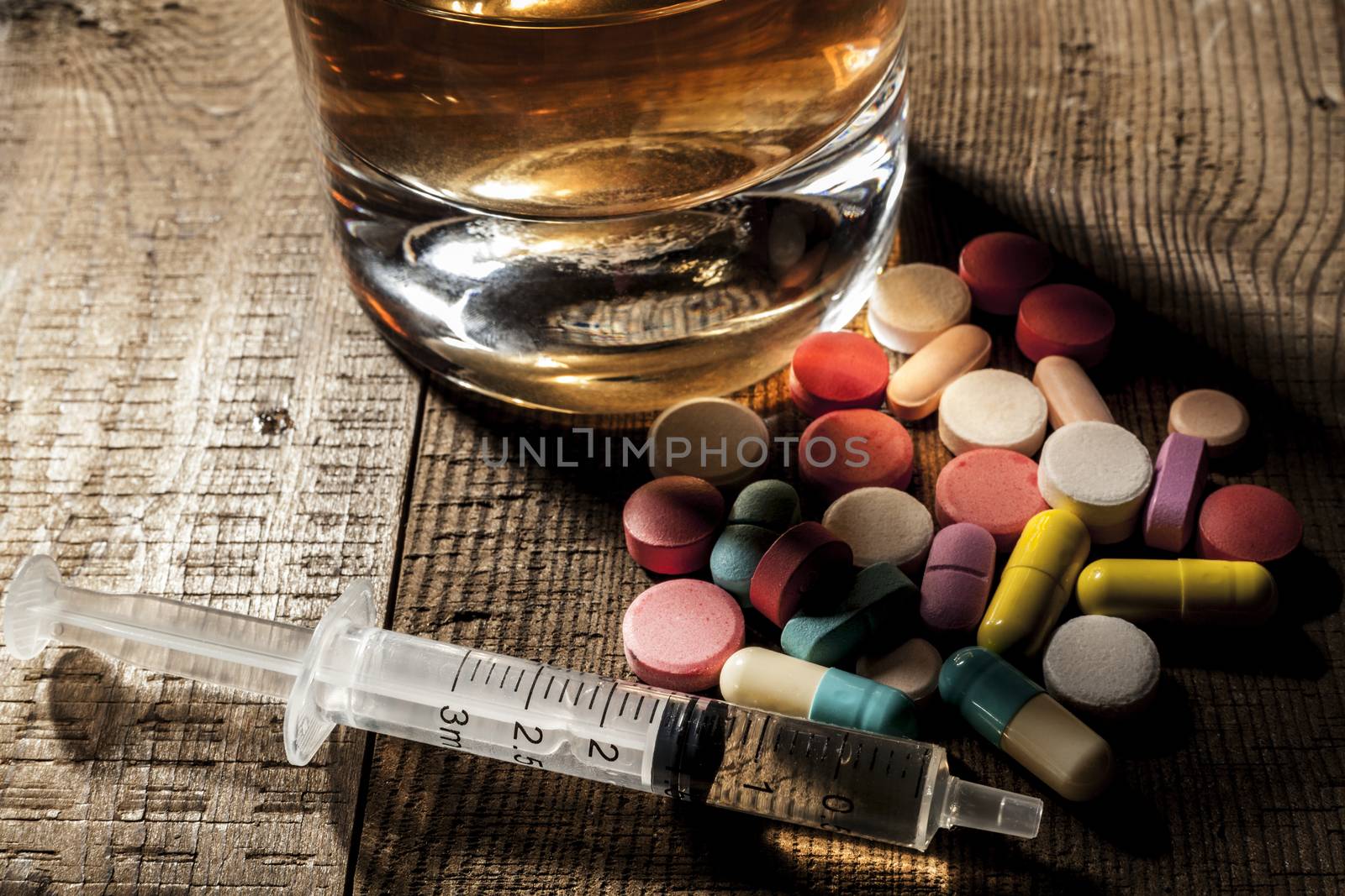 Alcohol and pills on table with shadow