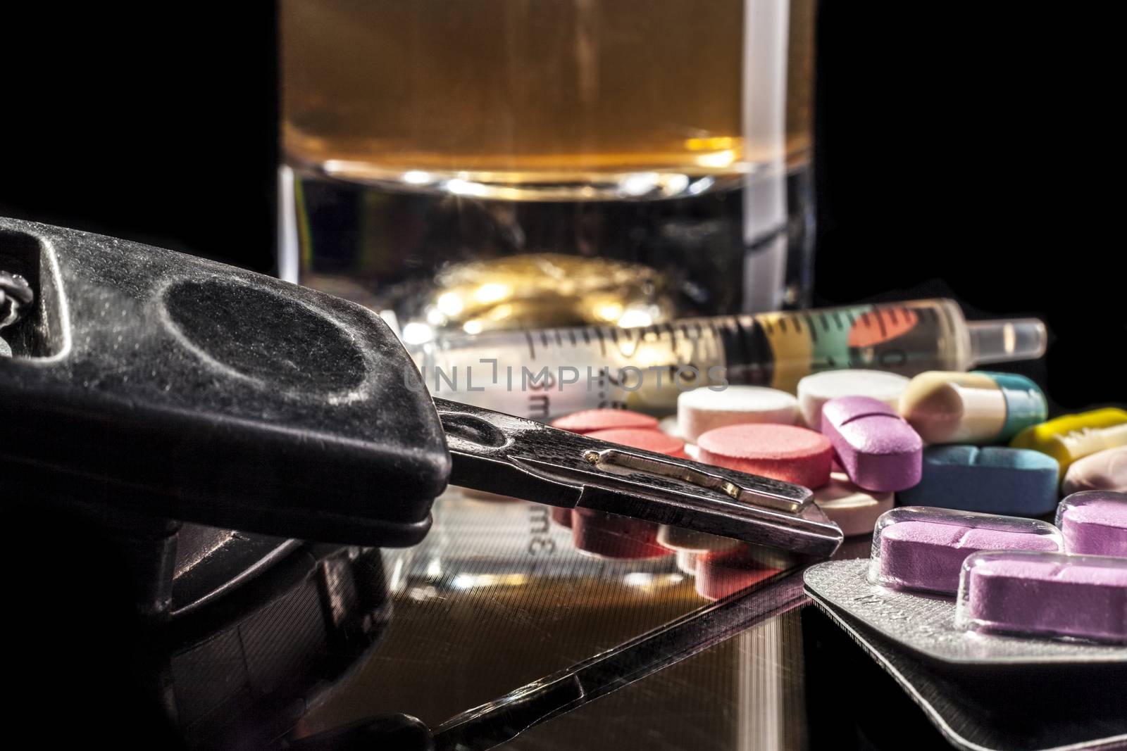 Car keys and pills isolated on black background with reflection