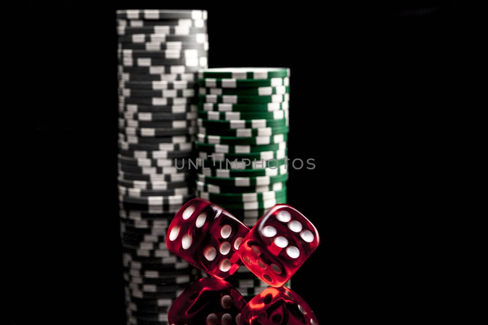 Dice and chips isolated on black background with reflexion